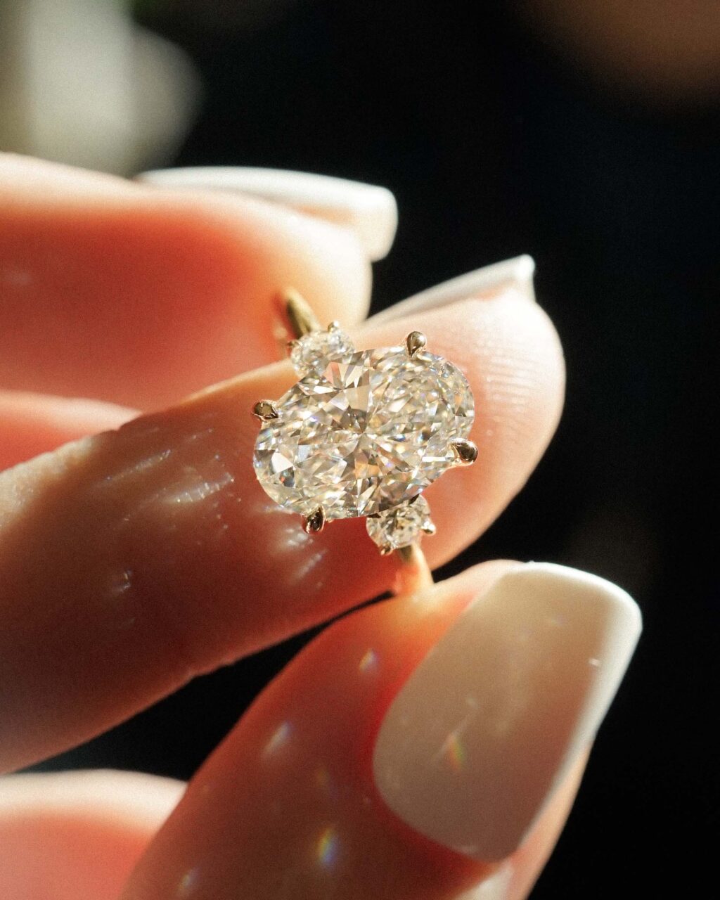 A center oval cut diamond is framed by two accent oval stones. 