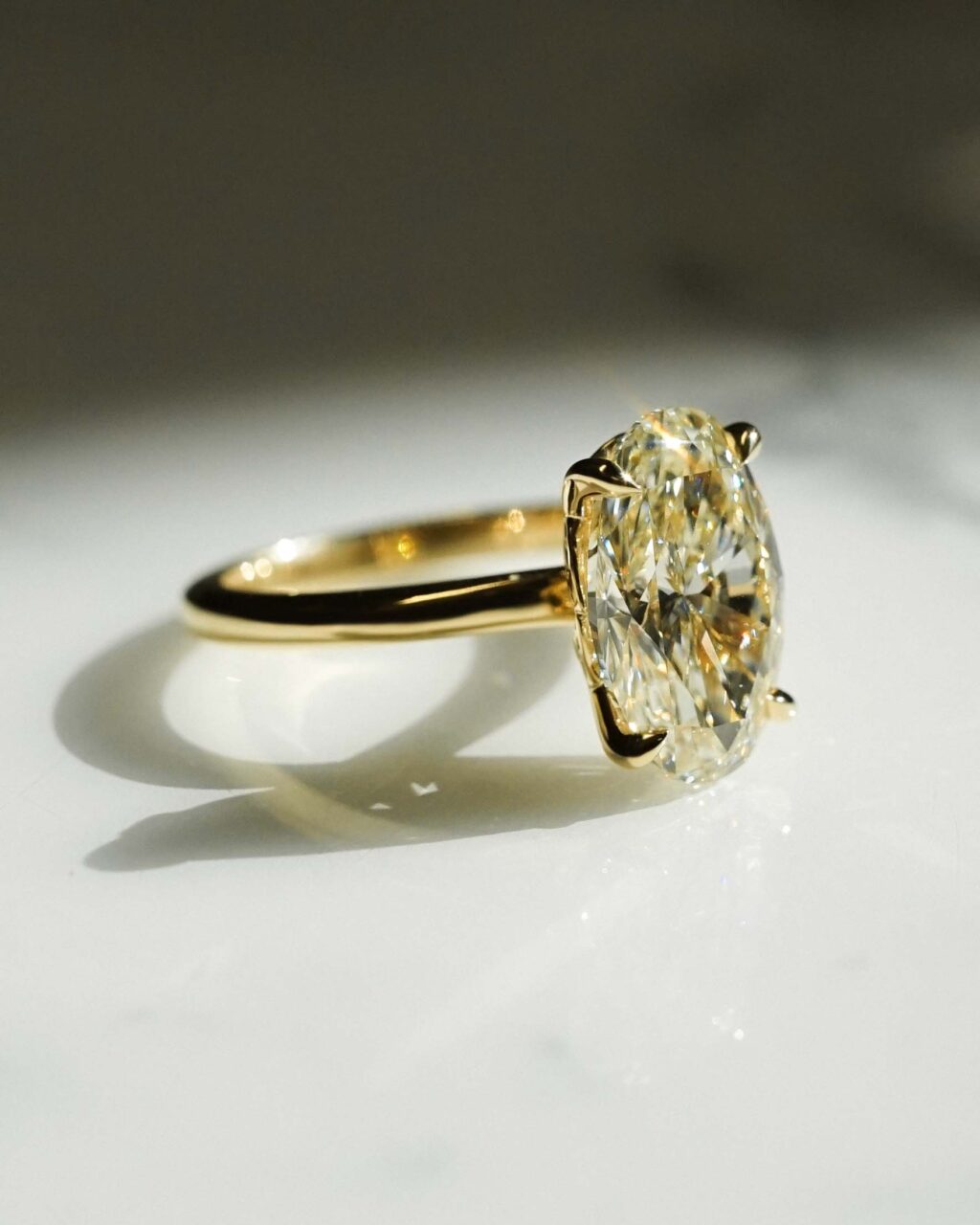 A side profile of a cushion cut champagne diamond ring with claw prongs 
