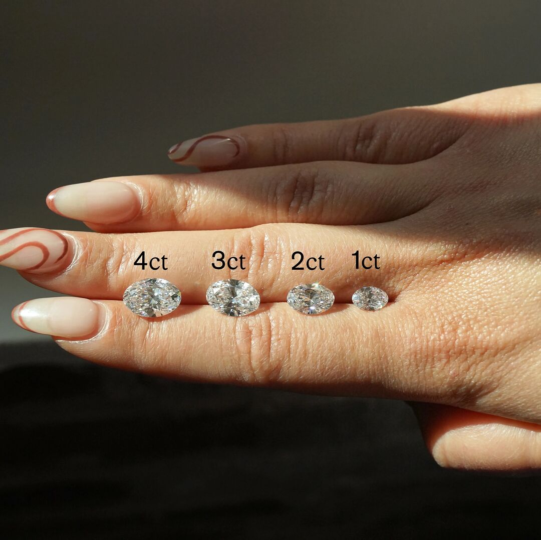 Four oval diamonds, labelled 4ct, 3ct, 2 ct, 1ct, demonstrate the variance in carat size