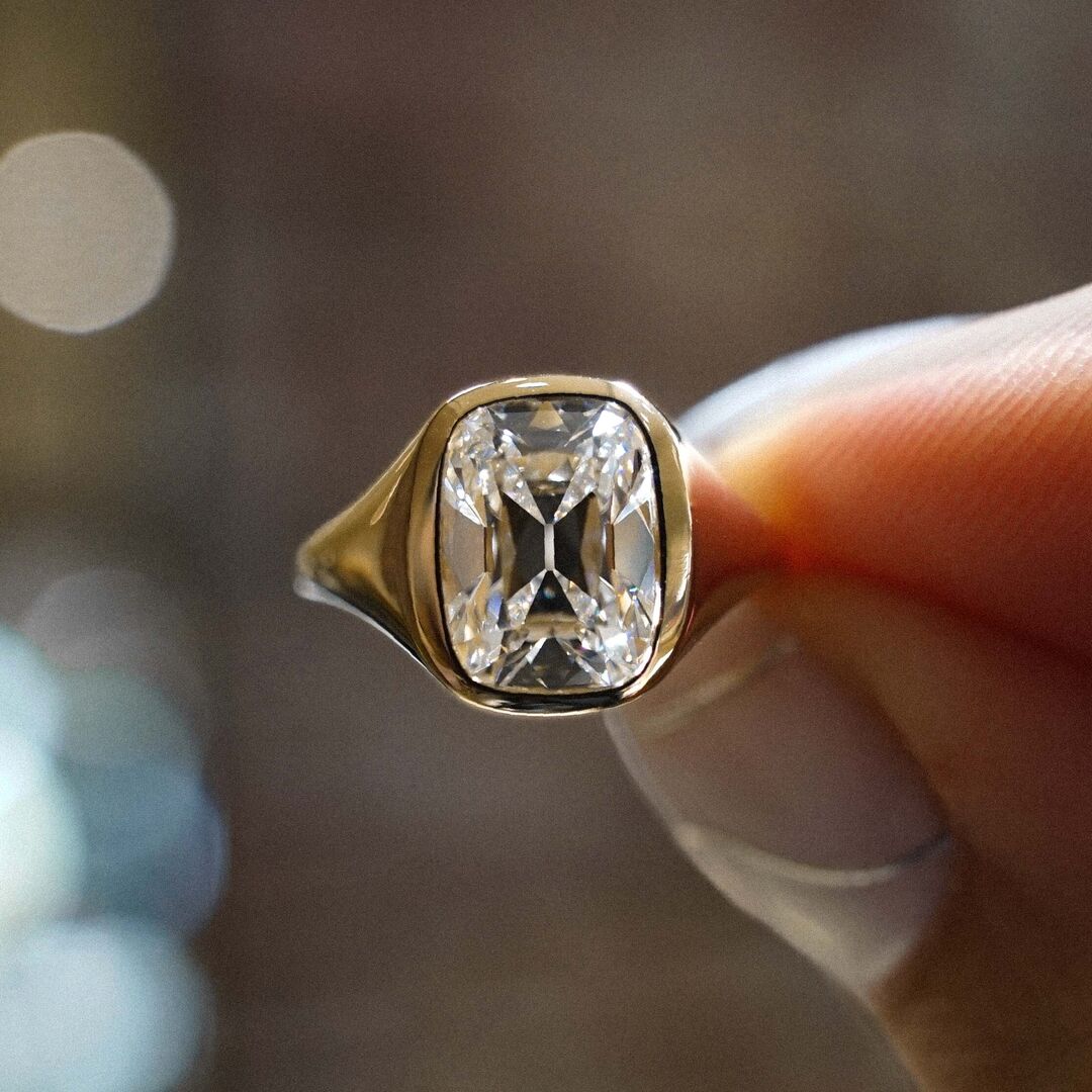 A bezel set old mione cut diamond in brushed yellow gold 