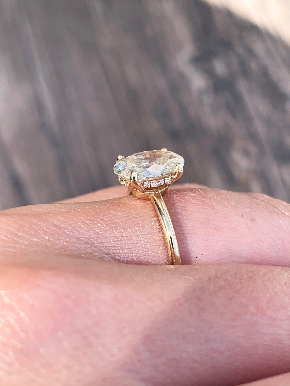 low profile oval solitaire with 1.8mm band and hidden halo and floral prongs in yellow gold