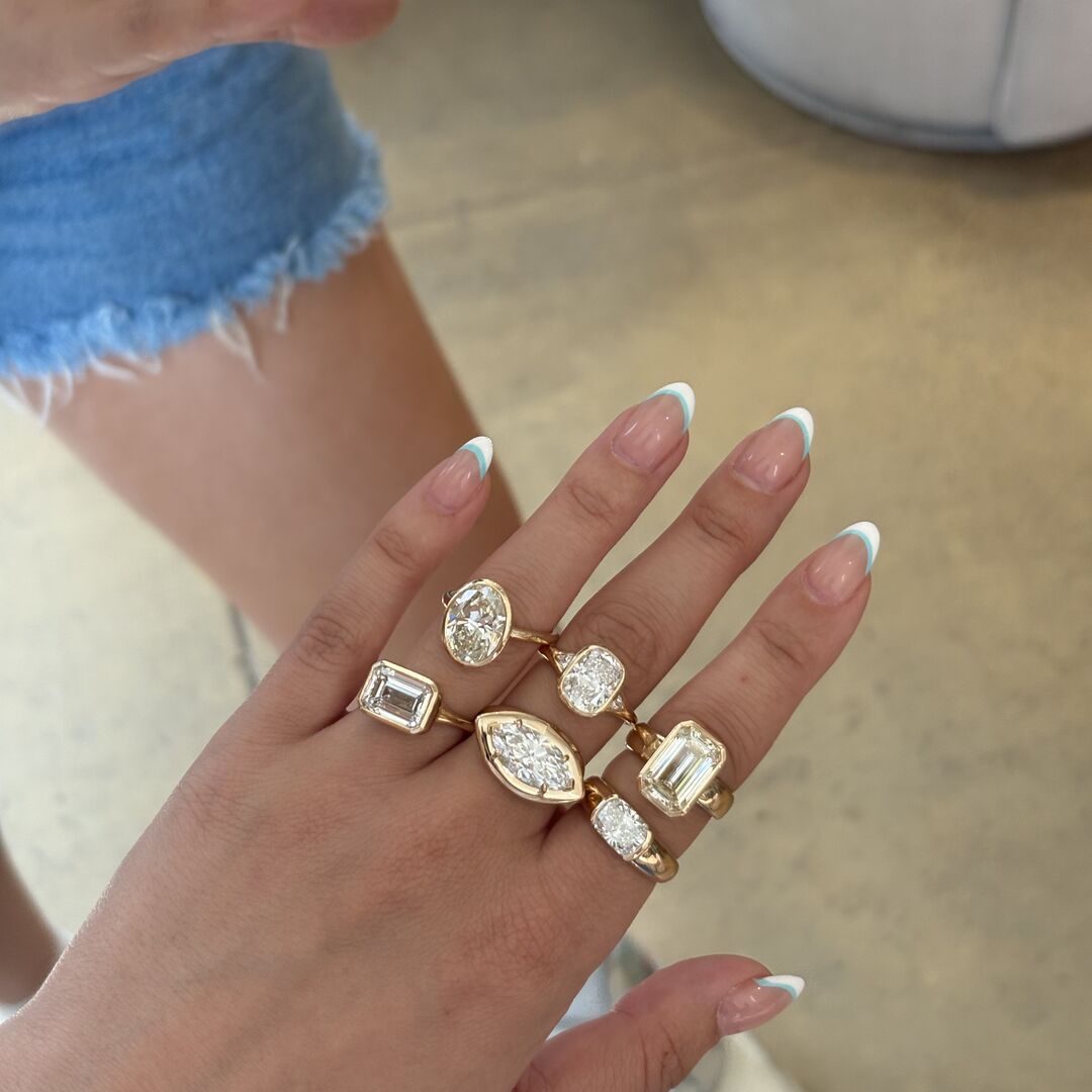 A woman in shorts wears six lab grown diamond engagement rings